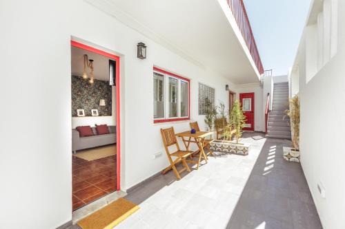 an open hallway with a table and chairs in a house at Pinheirinha Guest House in Alpiarça