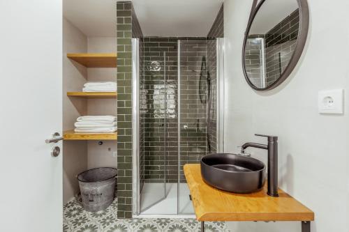a bathroom with a sink and a shower at Pinheirinha Guest House in Alpiarça