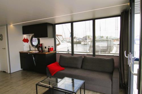 a living room with a couch and a large window at Hausboot Fjord Nordstern mit Dachterrasse in Schleswig in Schleswig