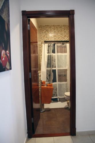 a bathroom with a glass door leading to a toilet at Tonono´s Village in Santa Maria de Guia de Gran Canaria
