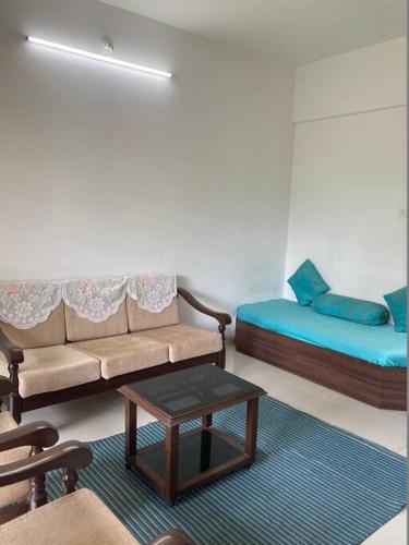een kamer met een bank, een bed en een tafel bij Secluded Serenity in Central Pune:Your Second home in Pune