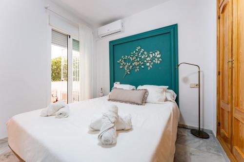 - une chambre avec un grand lit blanc et des serviettes dans l'établissement Vive Fuengirola, à Fuengirola