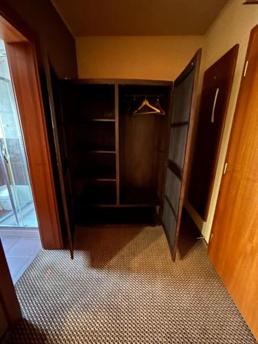a room with a closet with a door open at Penzion Benedikti in Prievidza
