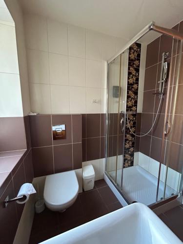 a bathroom with a shower and a toilet and a sink at Penzion Benedikti in Prievidza