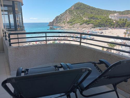 a chair sitting on a balcony overlooking a beach at Apartamento En la Cala de Finestrat in Cala de Finestrat
