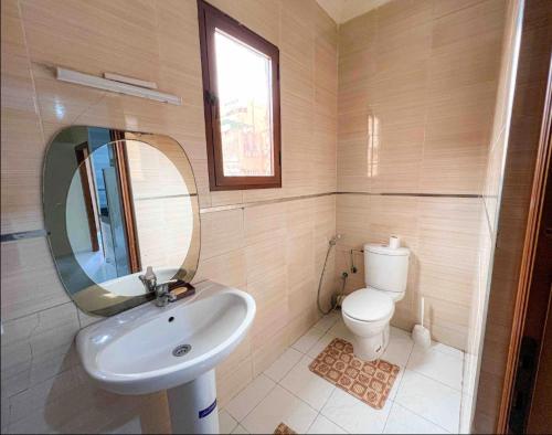 ein Badezimmer mit einem Waschbecken, einem Spiegel und einem WC in der Unterkunft Marrakech Mirage Home in Marrakesch