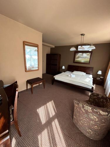 a bedroom with a bed and a table and a chair at Penzion Benedikti in Prievidza