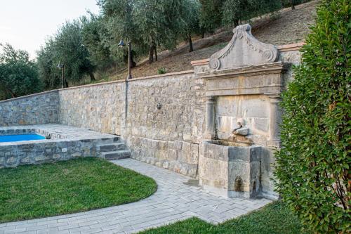 una pared de piedra con una fuente en un patio en L'Antica Fontana - Casa Vacanze B&B en Viggianello