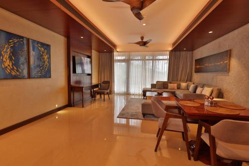 a living room with a couch and a table and chairs at Taj Wayanad Resort & Spa, Kerala in Wayanad