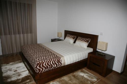 a bedroom with a bed and a night stand with a lamp at Casa de Vale Benfeito - Turismo Rural in Macedo de Cavaleiros