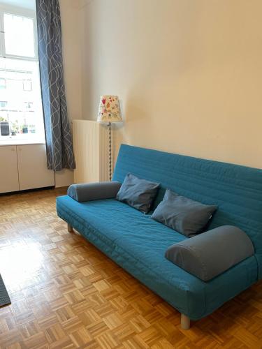 a blue couch sitting in a living room at Altbauwohnung im Herzen vom Lend in Graz