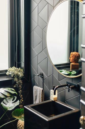 a bathroom with a black sink and a mirror at LohonoStays Uday Villa in Waki
