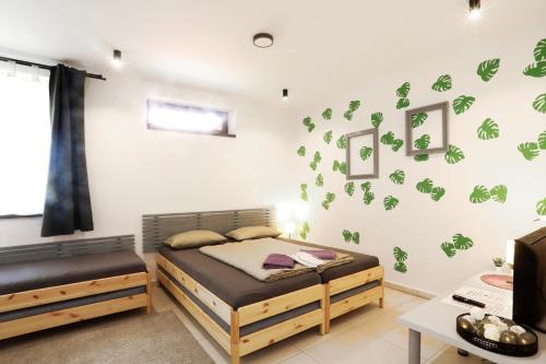 1 dormitorio con 2 camas y pared con calcomanías verdes en Apartmán Wellness Veselí en Veselí nad Moravou