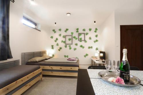 a bedroom with two beds and a table with a bottle of wine at Apartmán Wellness Veselí in Veselí nad Moravou