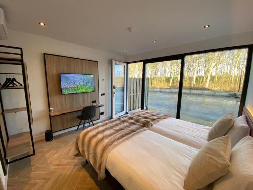 a bedroom with a large bed with a large window at HarTeluk Afsluitdijk Zurich in Zurich