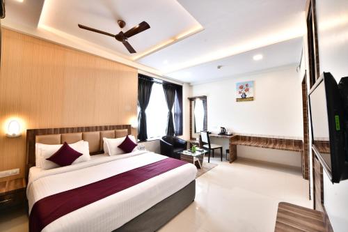a hotel room with a bed and a ceiling fan at Click Hotel Sagar Plaza Chakan, Pune in Chakan