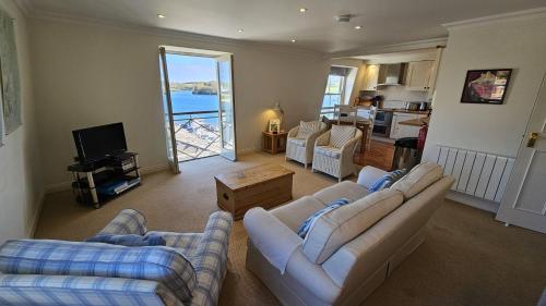 a living room with two couches and a kitchen at Pennant in Saint Mawes