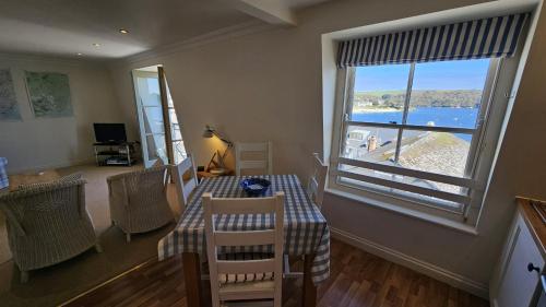 a dining room with a table and a large window at Pennant in Saint Mawes