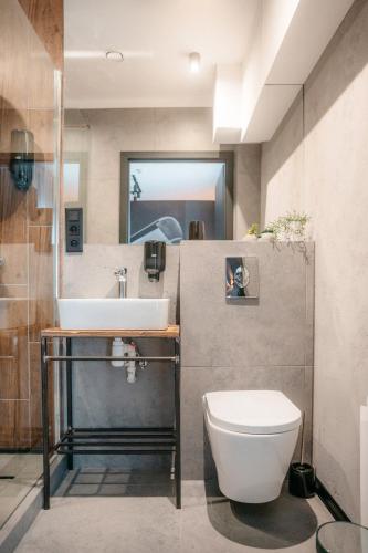 a bathroom with a white toilet and a sink at SLEEP WELL 1999 in Tychy