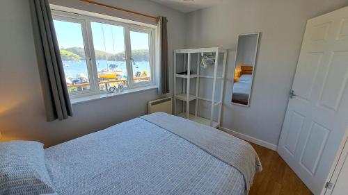 1 dormitorio con cama y ventana grande en Polmaro, en Saint Mawes