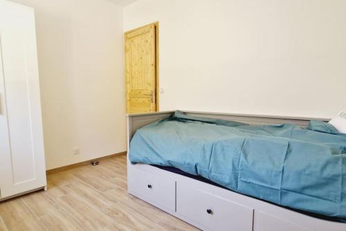 a bed in a white room with a door at Le Rocher YourHostHelper in Fontanil-Cornillon