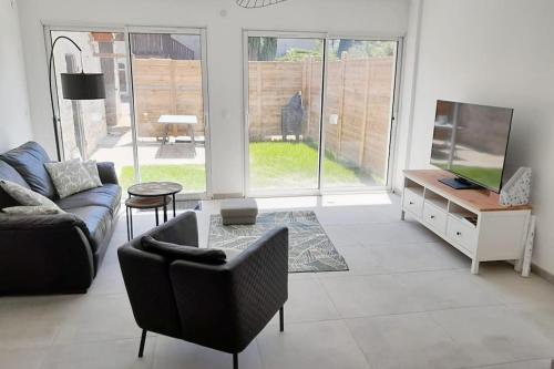 a living room with a couch and a tv at Le Rocher YourHostHelper in Fontanil-Cornillon