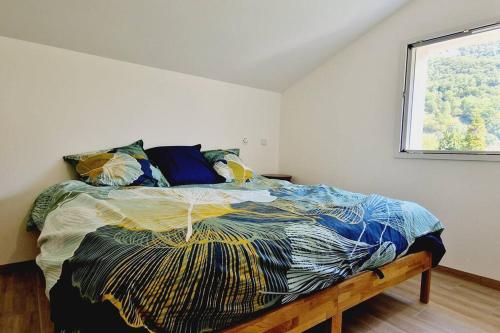 a bedroom with a large bed with a window at Le Rocher YourHostHelper in Fontanil-Cornillon