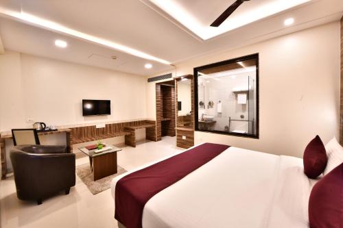 a hotel room with a bed and a bathroom at Click Hotel Sagar Plaza Chakan, Pune in Chakan