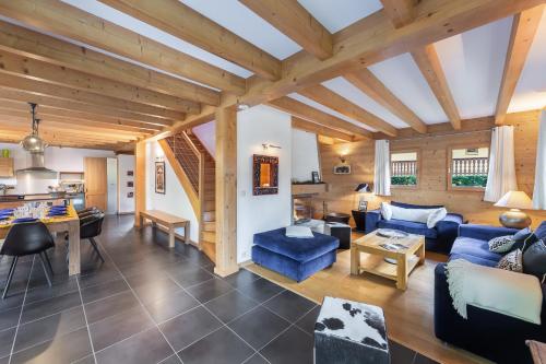 Elle comprend un salon doté de plafonds en bois et d'un canapé bleu. dans l'établissement Casa Linga - Chalet - BO Immobilier - Châtel, à Châtel