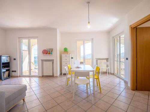a living room with a table and yellow chairs at Babyaccommodation Family Hills in Magliolo