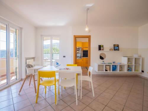 a living room with a table and chairs and a kitchen at Babyaccommodation Family Hills in Magliolo