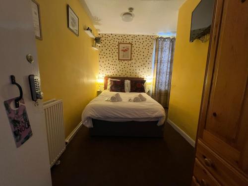 a small room with a bed and a yellow wall at Modern Rooms with SELF Check-In The Castle, Coldstream in Coldstream