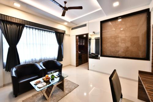 a living room with two chairs and a large screen at Click Hotel Sagar Plaza Chakan, Pune in Chakan