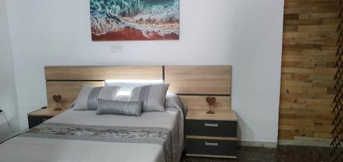 a bedroom with a bed and a painting on the wall at APARTAMENTO TURISTICO GUADIANA LOFT EXPERIENCE Dalia in Badajoz