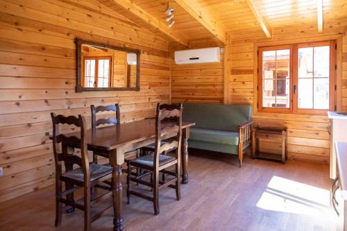 - une salle à manger dans une cabane en rondins avec une table et des chaises dans l'établissement ALBERGUE CONTRERAS, à Minglanilla