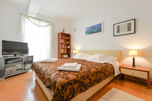 um quarto com uma cama grande e uma televisão em Apartments Doda em Zadar