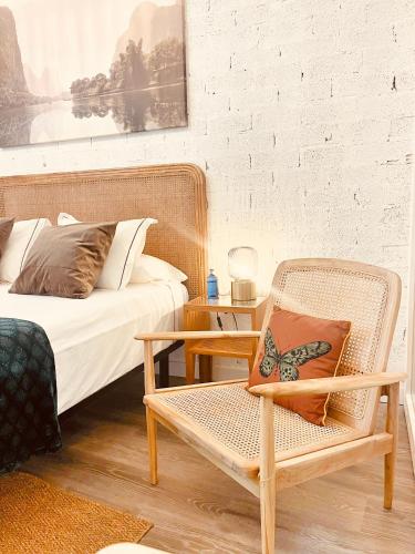 a bedroom with a bed and a chair with a butterfly pillow at Tennessee Studio Malaga in Málaga