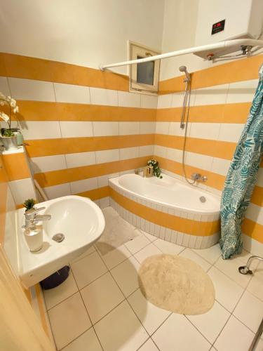 ein Badezimmer mit einer Badewanne, einem Waschbecken und einer Badewanne in der Unterkunft Sziv Apartment - Modern and Comfortable in Budapest
