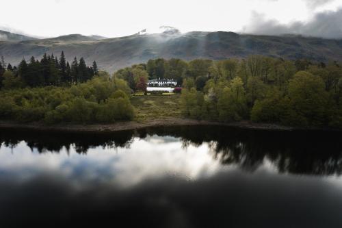 a house is sitting on the shore of a lake at Dale Head Hall Lakeside Hotel in Keswick