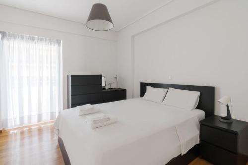 1 dormitorio con 1 cama blanca grande y cabecero negro en 3 Bedroom Apartment Near The Mall/Olympic Stadium, en Atenas