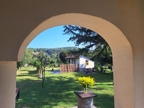 an archway with a view of a house in a yard at Patak Üdülőház (Ferienhaus) in Nagyvisnyó