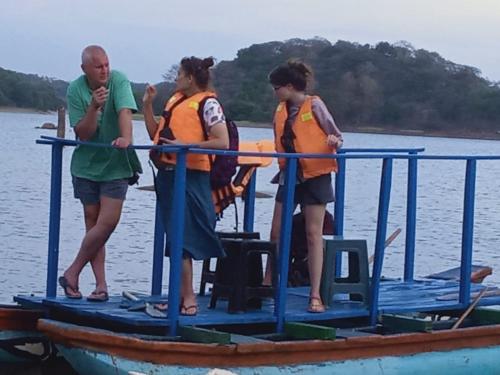 a group of people standing on a boat in the water at Green Garden Homestay in Giritale