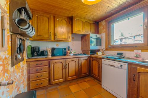 - une cuisine avec des placards en bois et un lave-vaisselle blanc dans l'établissement Chalet Corzelet ski in - ski out - Happy Rentals, à Chamonix-Mont-Blanc