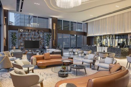 a lobby with couches and chairs and a television at DoubleTree by Hilton Sanliurfa in Sanlıurfa