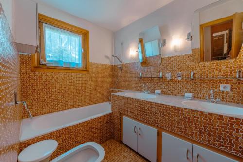 a bathroom with two sinks and two mirrors at Chalet Corzelet ski in - ski out - Happy Rentals in Chamonix-Mont-Blanc