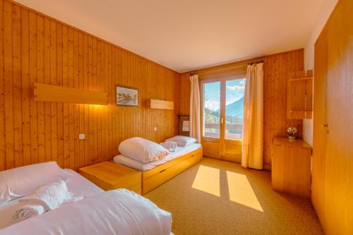 a bedroom with two beds and a large window at Chalet Corzelet ski in - ski out - Happy Rentals in Chamonix-Mont-Blanc