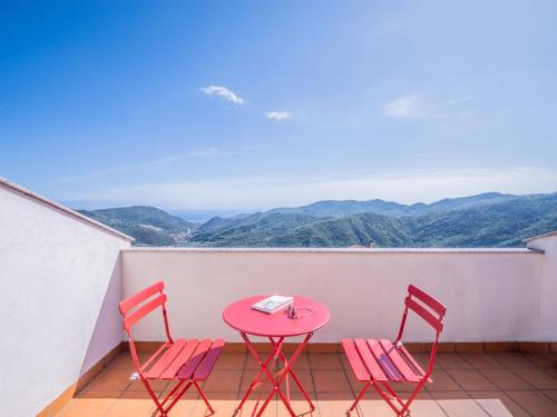 a table and chairs on a balcony with mountains at Babyaccommodation Family Hills in Magliolo