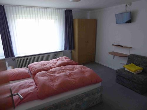 1 dormitorio con cama, ventana y silla en Landgasthof Lüder, en Lüder