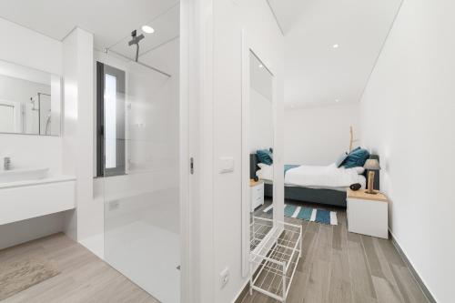 bagno bianco con lavandino e letto di Villa Paraiso - By SCH a São Martinho do Porto