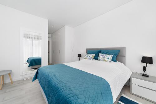 1 dormitorio con 1 cama grande con manta azul en Villa Paraiso SCH073 en São Martinho do Porto